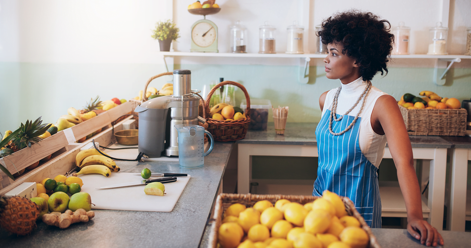 A web developer in Kenya standing in front of a counter full of fruit.